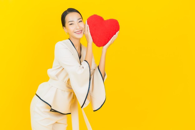 beautiful young business asian woman with heart-shape pillow
