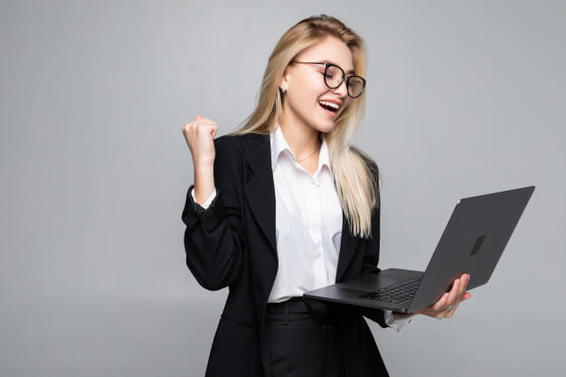 Portrait of a young happy business woman with a laptop with win gesture
